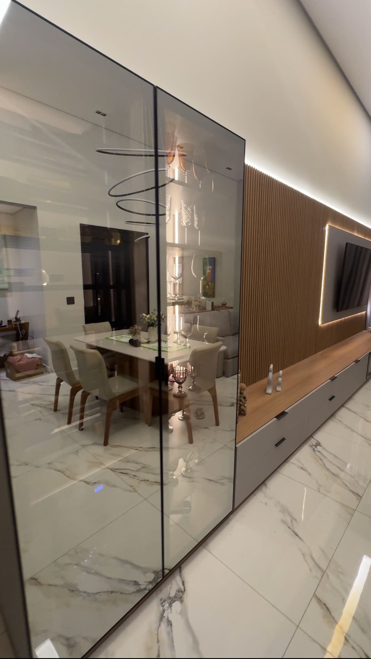Sala de jantar integrada com cristaleira em vidro reflecta, painel ripado de madeira e moveis planejados em Piracicaba SP - Decora Sob Medida